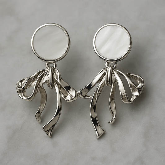 Elegant silver earrings with round mother-of-pearl studs and flowing ribbon-like drop design.