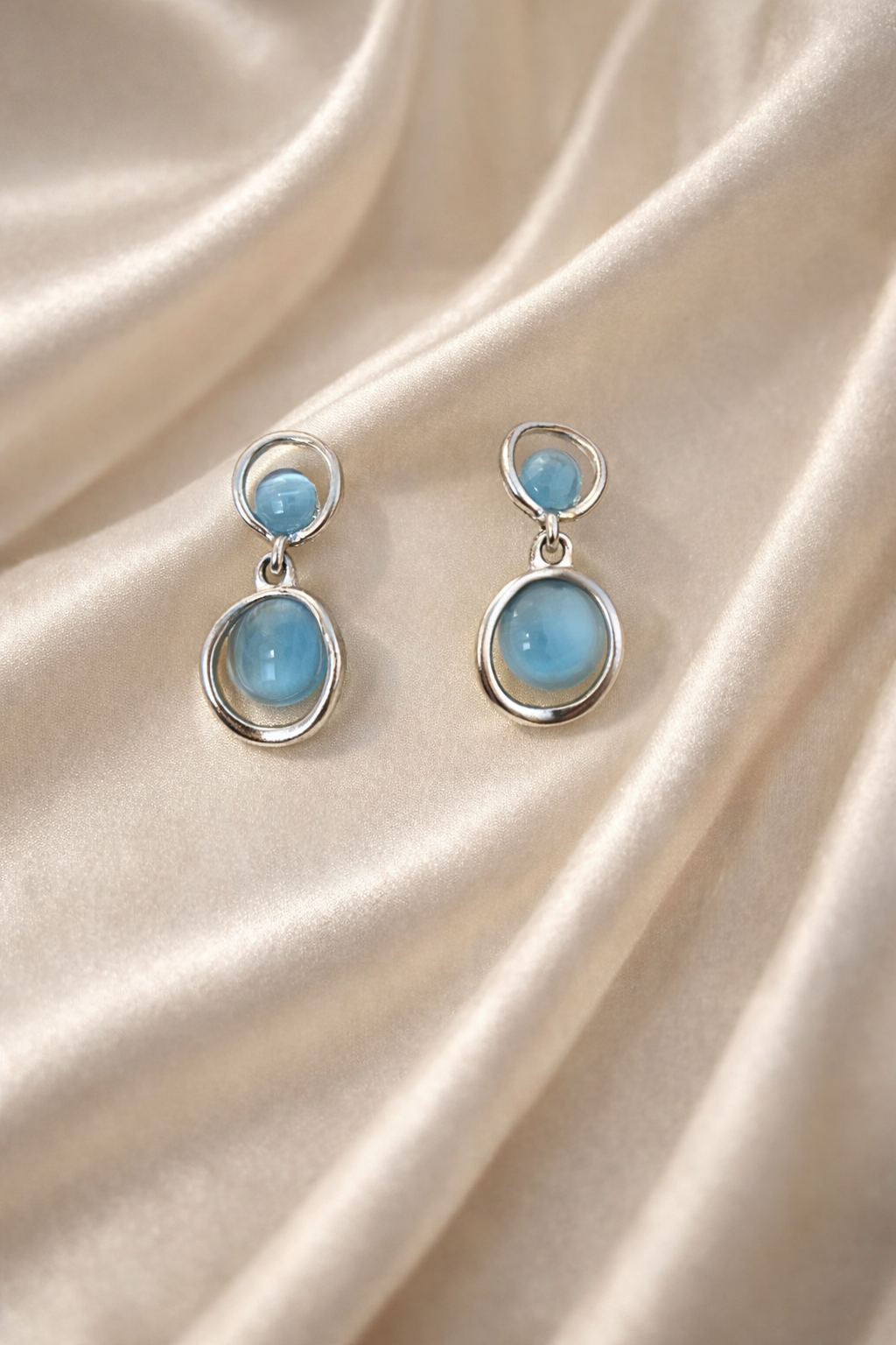 The earrings on a beige cloth background 