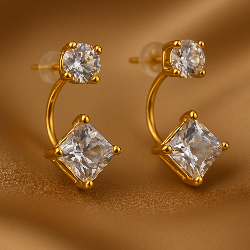 Gold hoop earrings with clear gemstones on a brown background