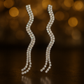 Pair of diamond earrings on a dark background with bokeh effect
