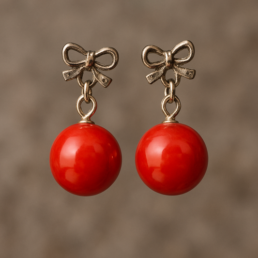 Pair of silver bow earrings with glossy red spherical drops