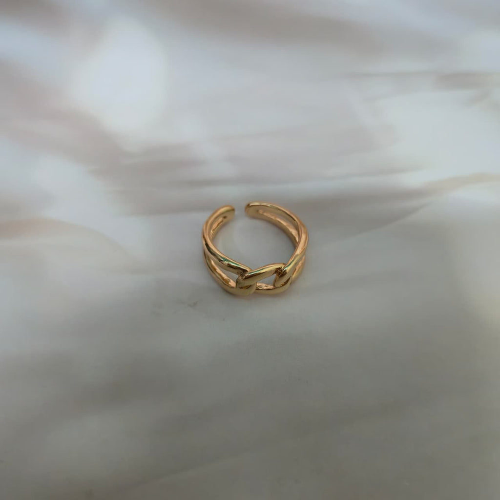 Minimal gold snake-style adjustable ring with anti-tarnish finish on red background