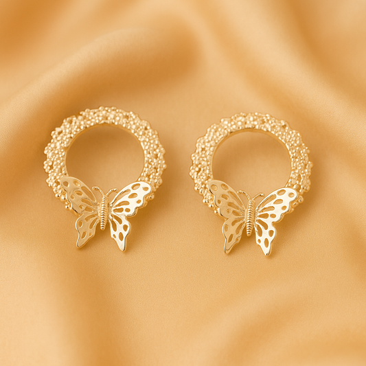 Silver-toned circular stud earrings featuring a textured, beaded design with a detailed butterfly charm at the base