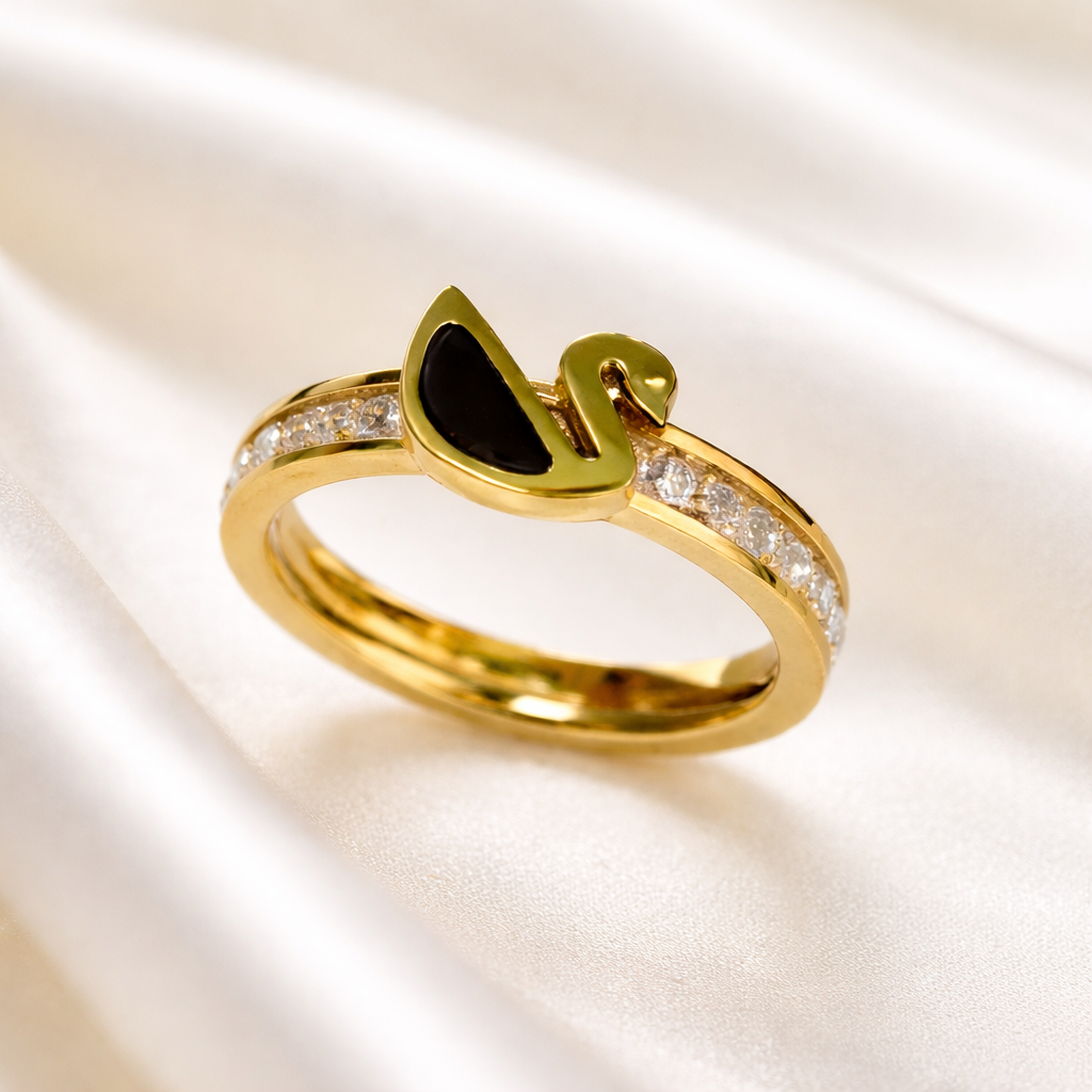 Gold ring with black stone on a white cloth. 