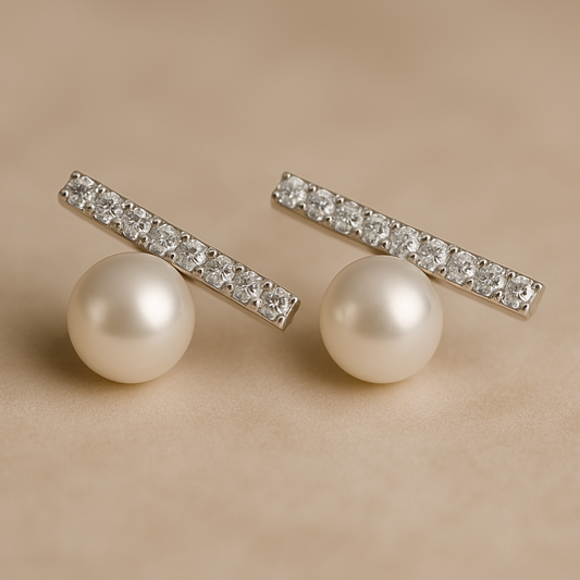Elegant stud earrings featuring a row of sparkling crystals set in a horizontal bar above a single round pearl