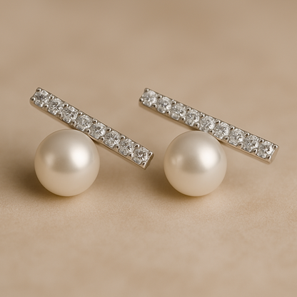 Elegant stud earrings featuring a row of sparkling crystals set in a horizontal bar above a single round pearl